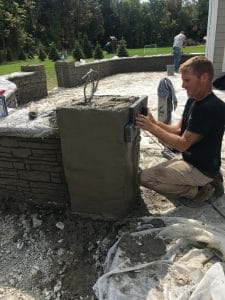 man kneeling doing concrete work